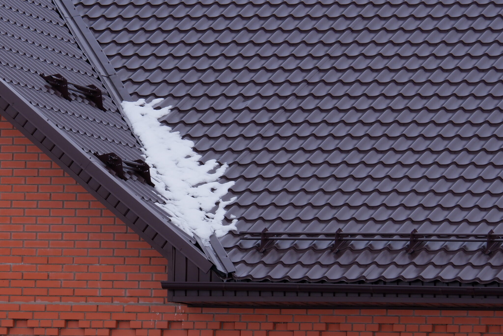 Tubular snow retaining device on the roof. Selective focus.